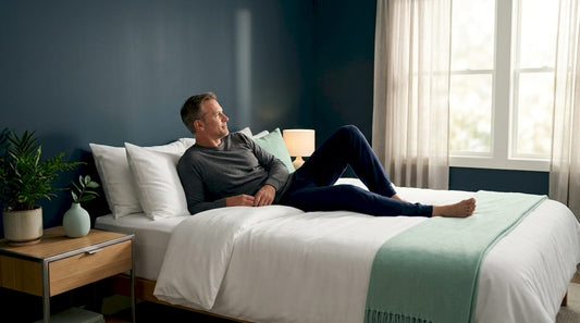 Man resting on mattress in sunlit bedroom
