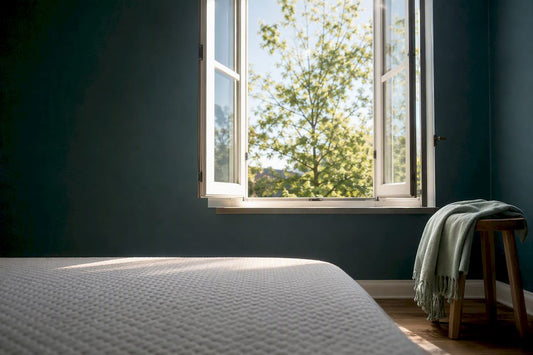 Open bedroom window beside mattress edge