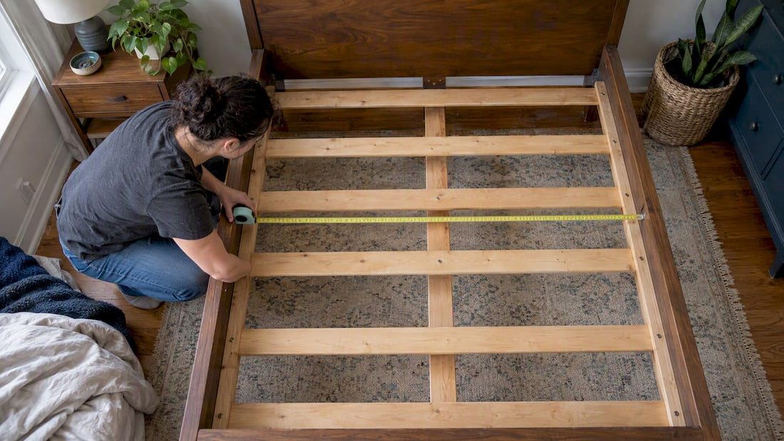 Homeowner measuring a bed frame for base fit